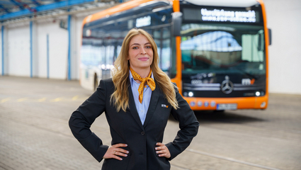 Eine Busfahrerin der Rhein-Neckar-Verkehr GmbH (rnv) steht vor einem elektrisch betriebenen eCitaro-Bus.