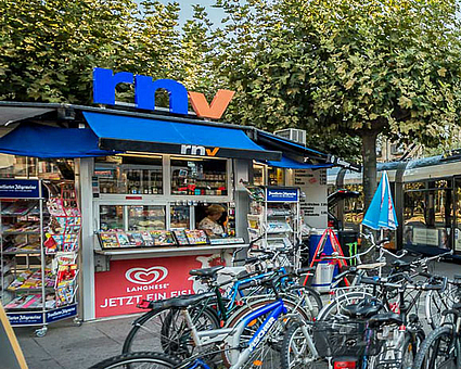 rnv-Verkaufsstelle am Heidelberger Bismarckplatz, zwei Straßenbahnen im Hintergrund