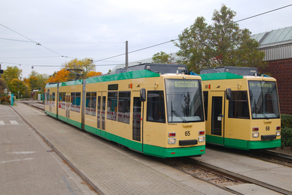 Zwei beige-grüne Straßenbahnen stehen nebeneinander im Betriebshof in Ludwigshafen-Rheingönheim. Demnächst werden sie nach Schoneiche bei Berlin transportiert.