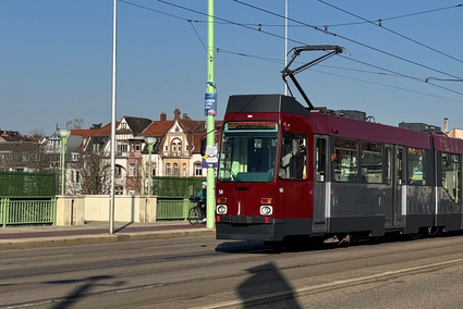 Eine grau-rote Bahn steht auf einer großen Brücke in Heidelberg.