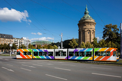 Straßenbahn in Regenbogenfarben vor dem Mannheimer Wasserturm