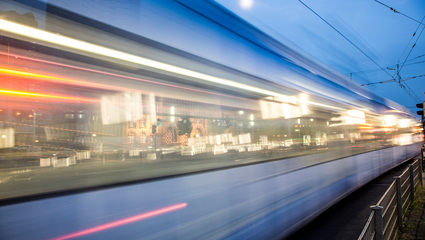 Verschwommene Lichter einer Straßenbahn, die an der Alten Feuerwache in Mannheim vorbeifährt