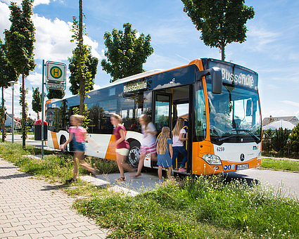 Schüler steigen aus einem Bus der rnv-Busschule aus. 