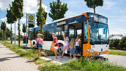 Schüler steigen aus einem Bus der rnv-Busschule aus. 