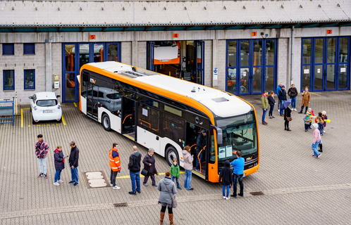 rnv: Tag der offenen Tür vor der Bushalle Ein Bus der rnv steht beim Tag der offenen Tür der rnv vor der Bushalle auf dem Betriebshofgelände und ist umringt von Besucherinnen und Besuchern.