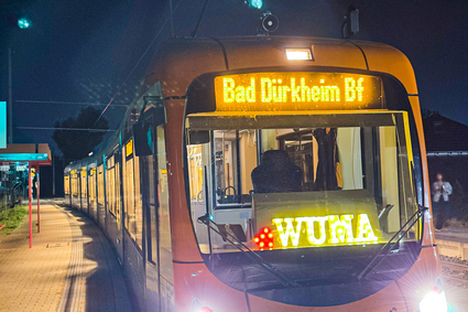 Eine Straßenbahn vom Typ RNV mit der Leuchtschrift "WUMA" im Fahrerfenster.