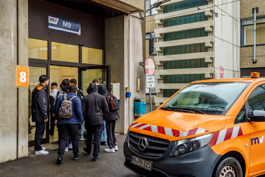 Schülerinnen und Schüler vor einem Betriebsgebäude auf dem rnv-Betriebshof in Mannheim.
