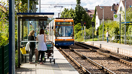 Familie mit Kinderwagen an der barrierefreien Haltestelle Wallstadt Ost