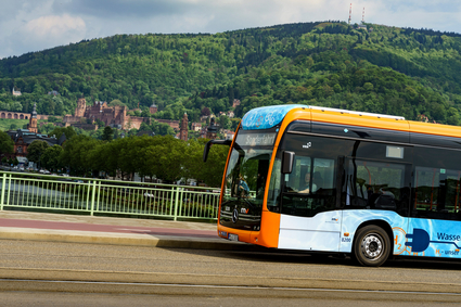 Ein rnv-Bus des Typs H2-eCitaro in Heidelberg vor dem Panorama mit dem Heidelberger Schloss.