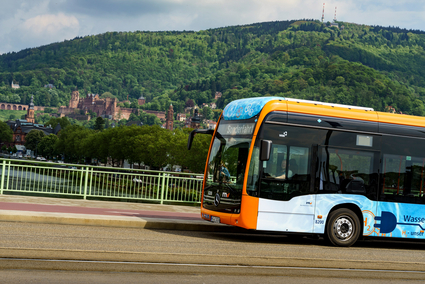 Ein rnv-Bus des Typs H2-eCitaro in Heidelberg vor dem Panorama mit dem Heidelberger Schloss.