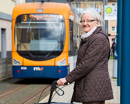 Seniorin mit Rollator an einer barrierefreien Stadtbahnhaltestelle